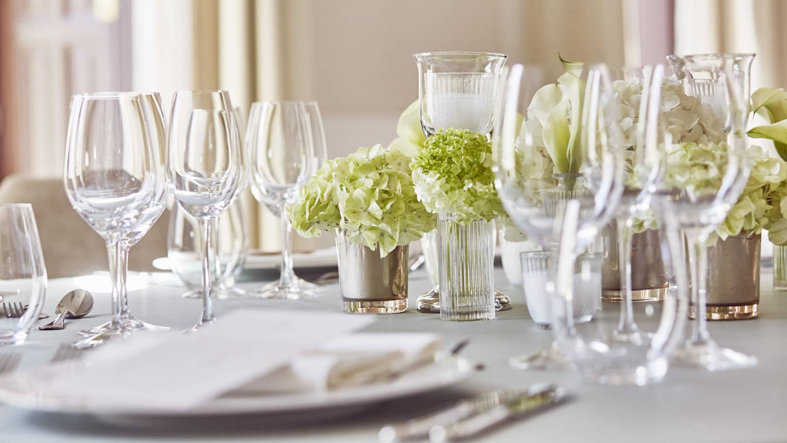 Place setting with plate, two wine glasses, one water glass, flower centerpiece