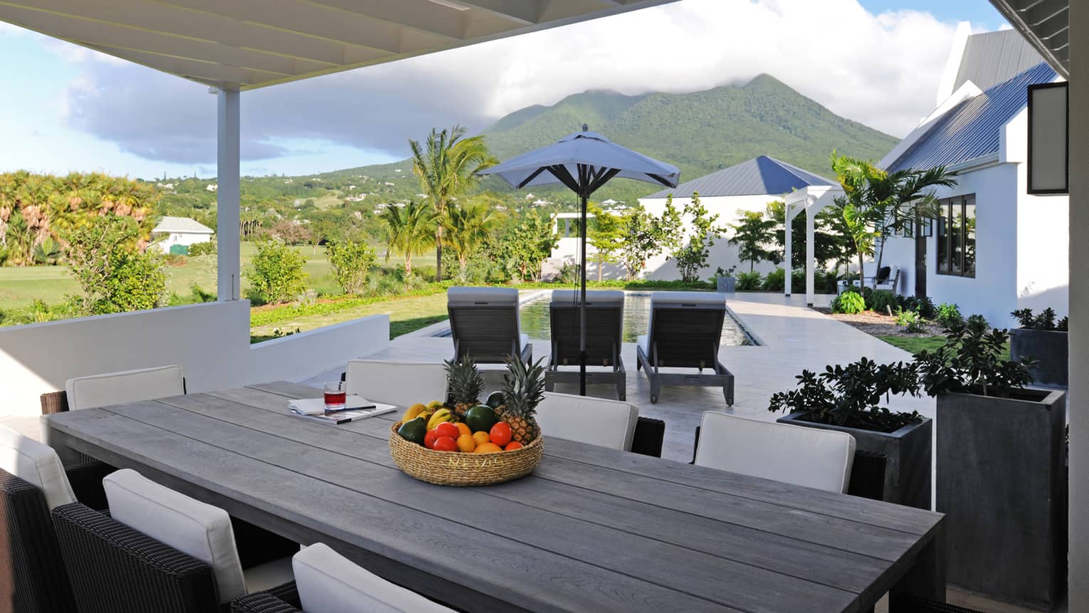 Pinney's Beach Residence Villa long patio dining table, wicker bowl with fruit