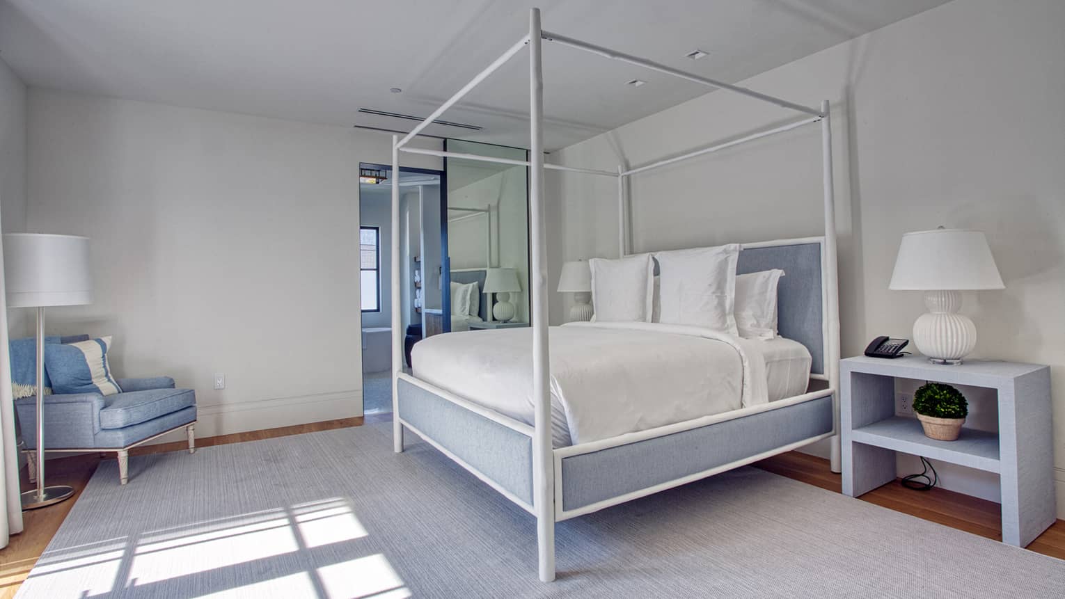 White and light blue bedroom with four-poster king bed