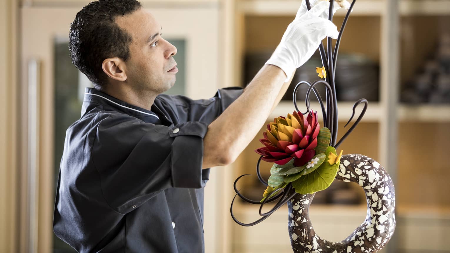 A hotel member decorating the hotel with flowers and plants.