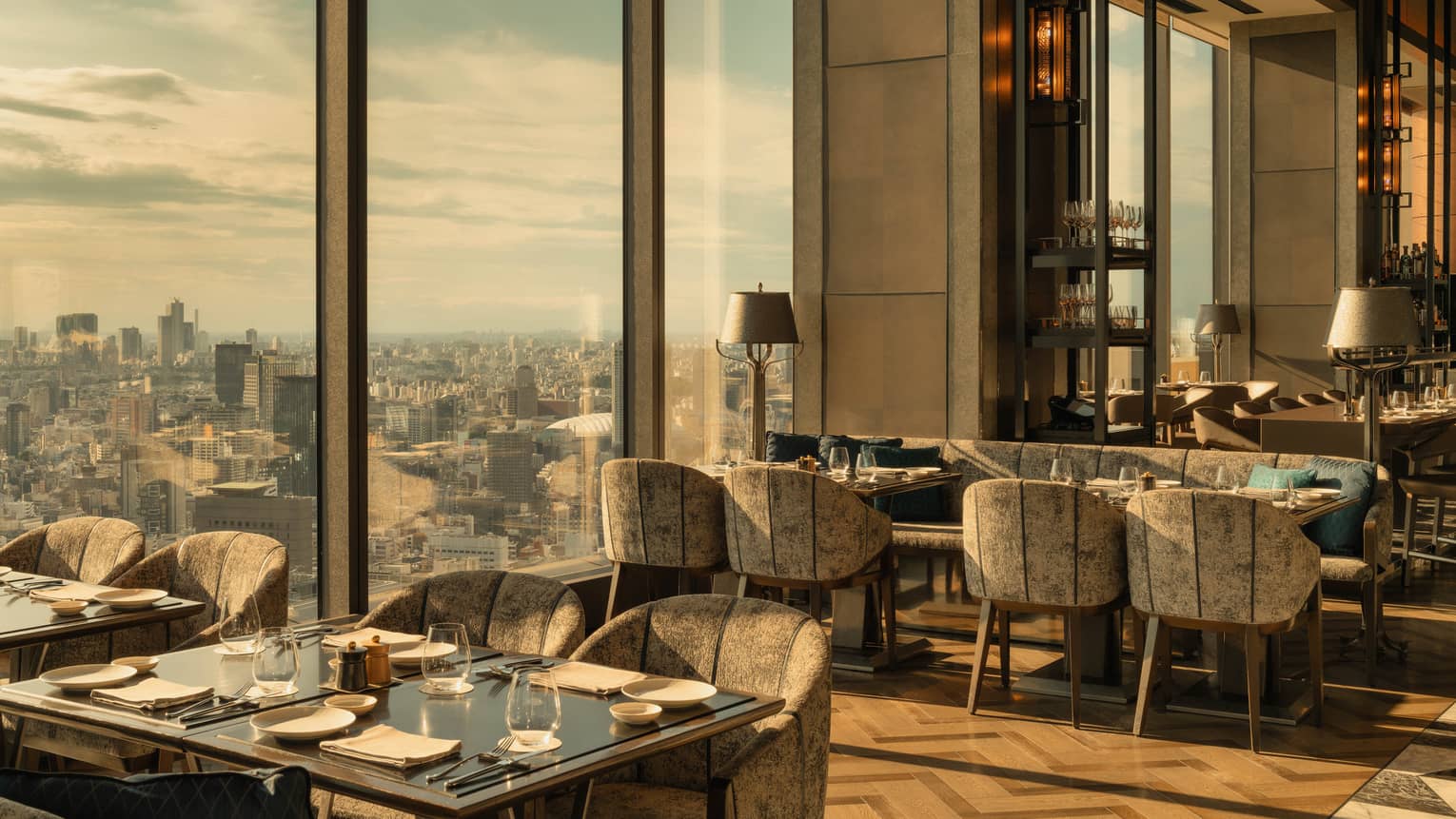 Luxury hotel restaurant with parquet floors, modern seating and floor-to-ceiling city views