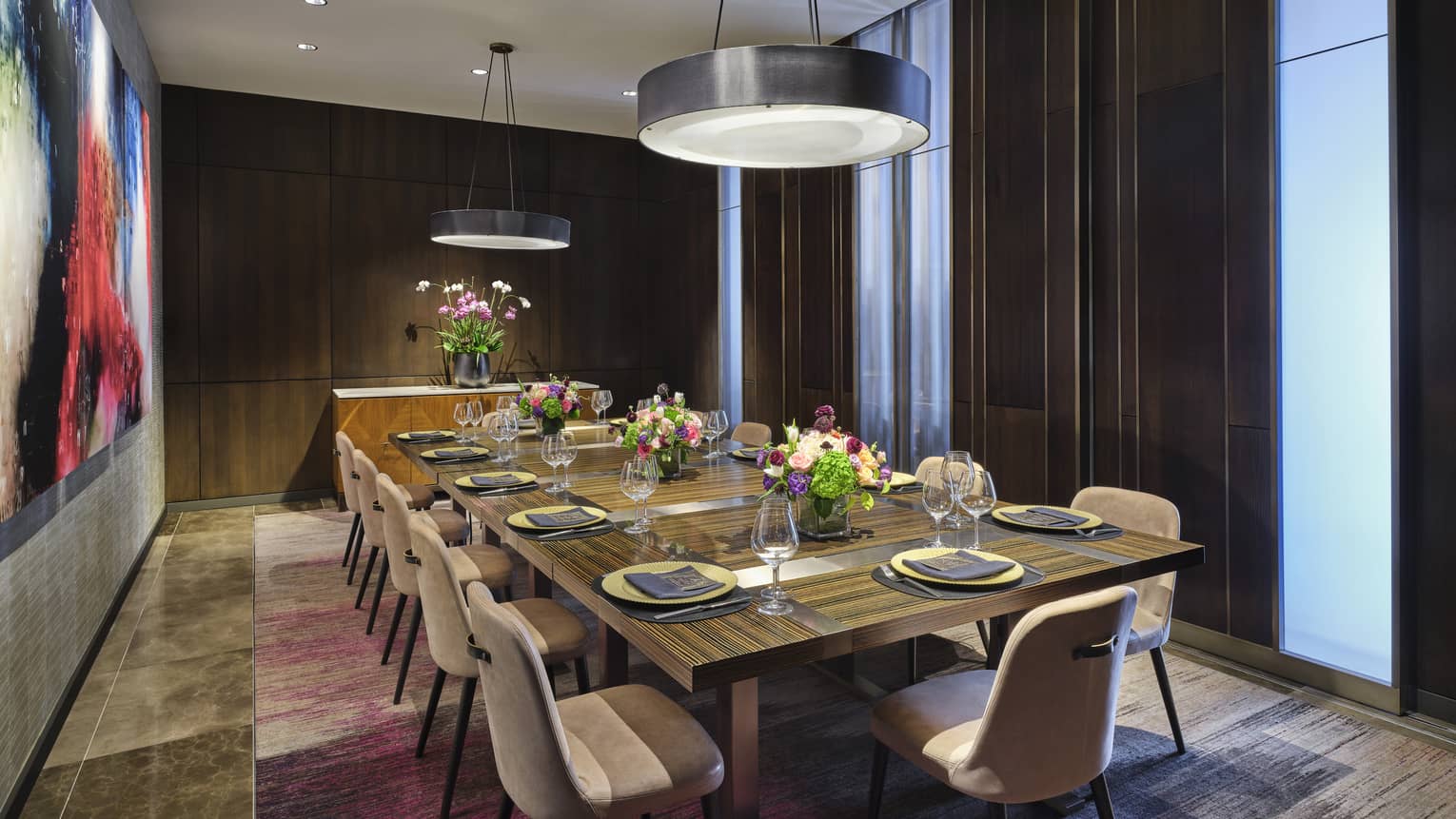 Room with table in the centre of the room and two circular lights above.