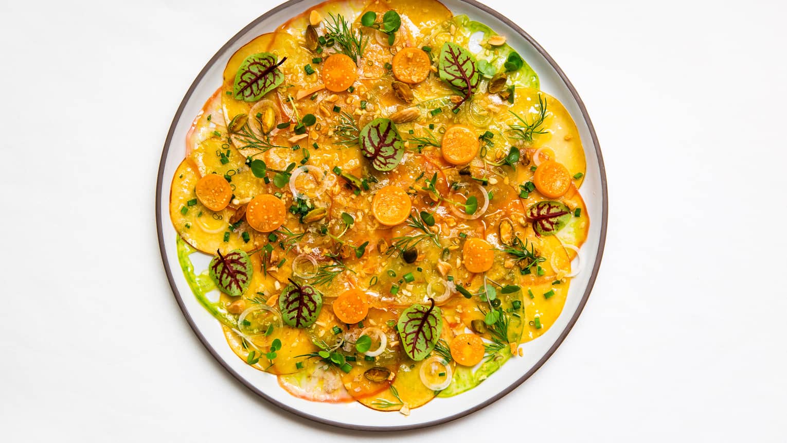 Sicilian pistachios, chives and ginger vinaigrette on a white plate.