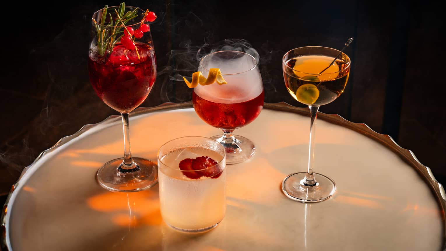 Four colourful cocktails on a round table