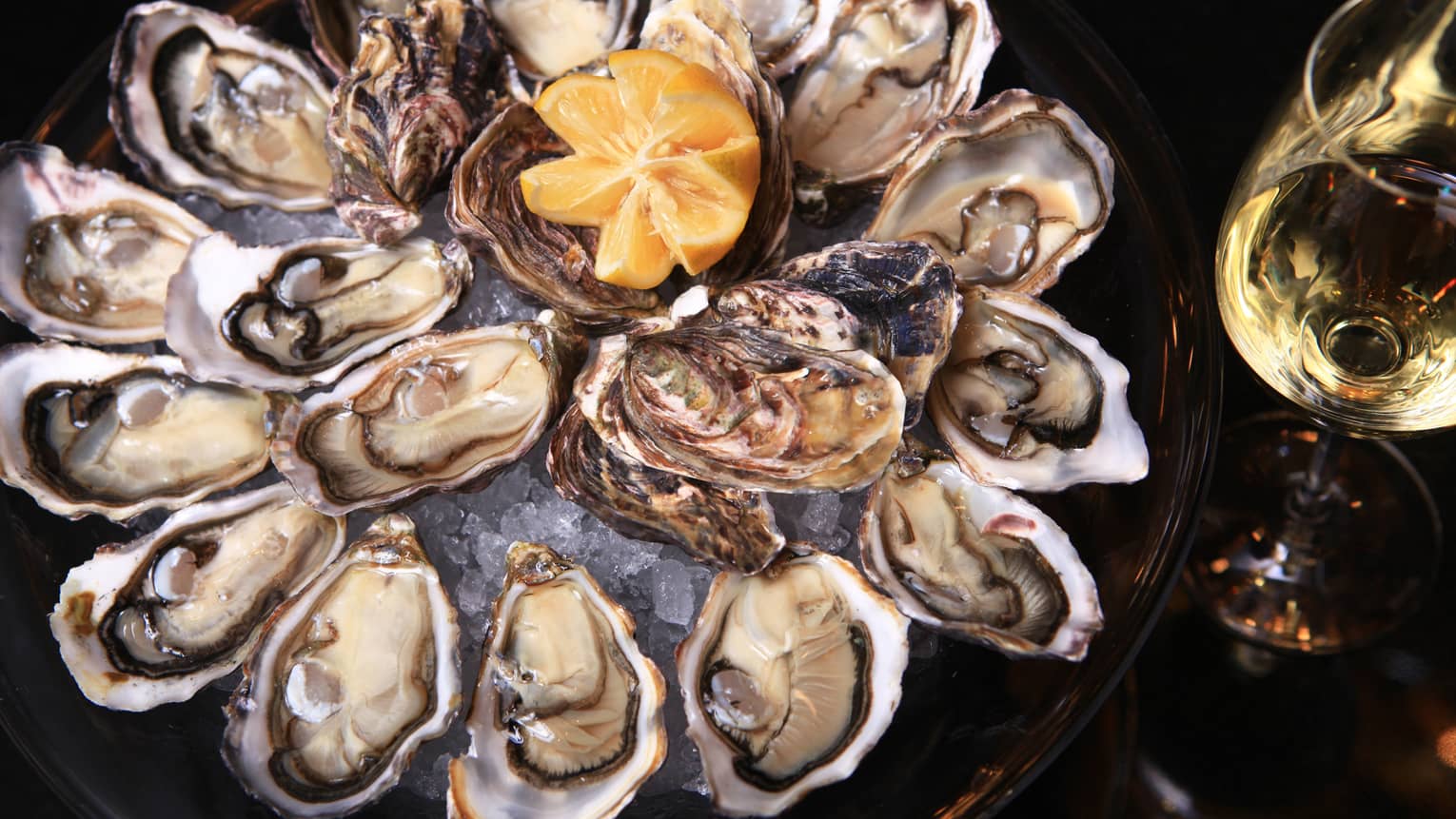 Fresh oysters in half shell arranged on platter 
