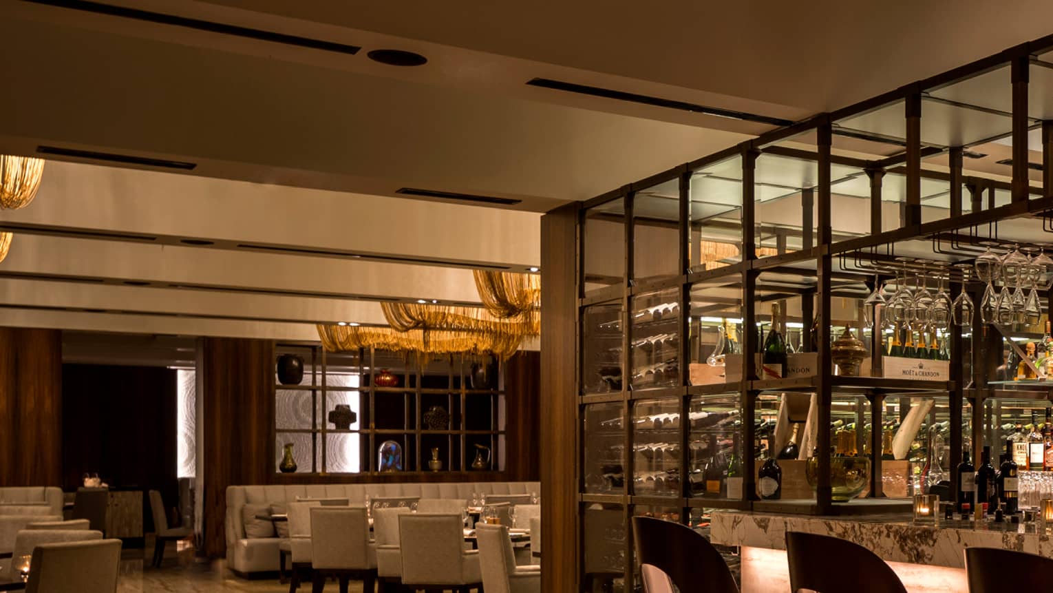 Modern framed bar with bartender, brown curved-back barstools and chairs, round tables, wood floor