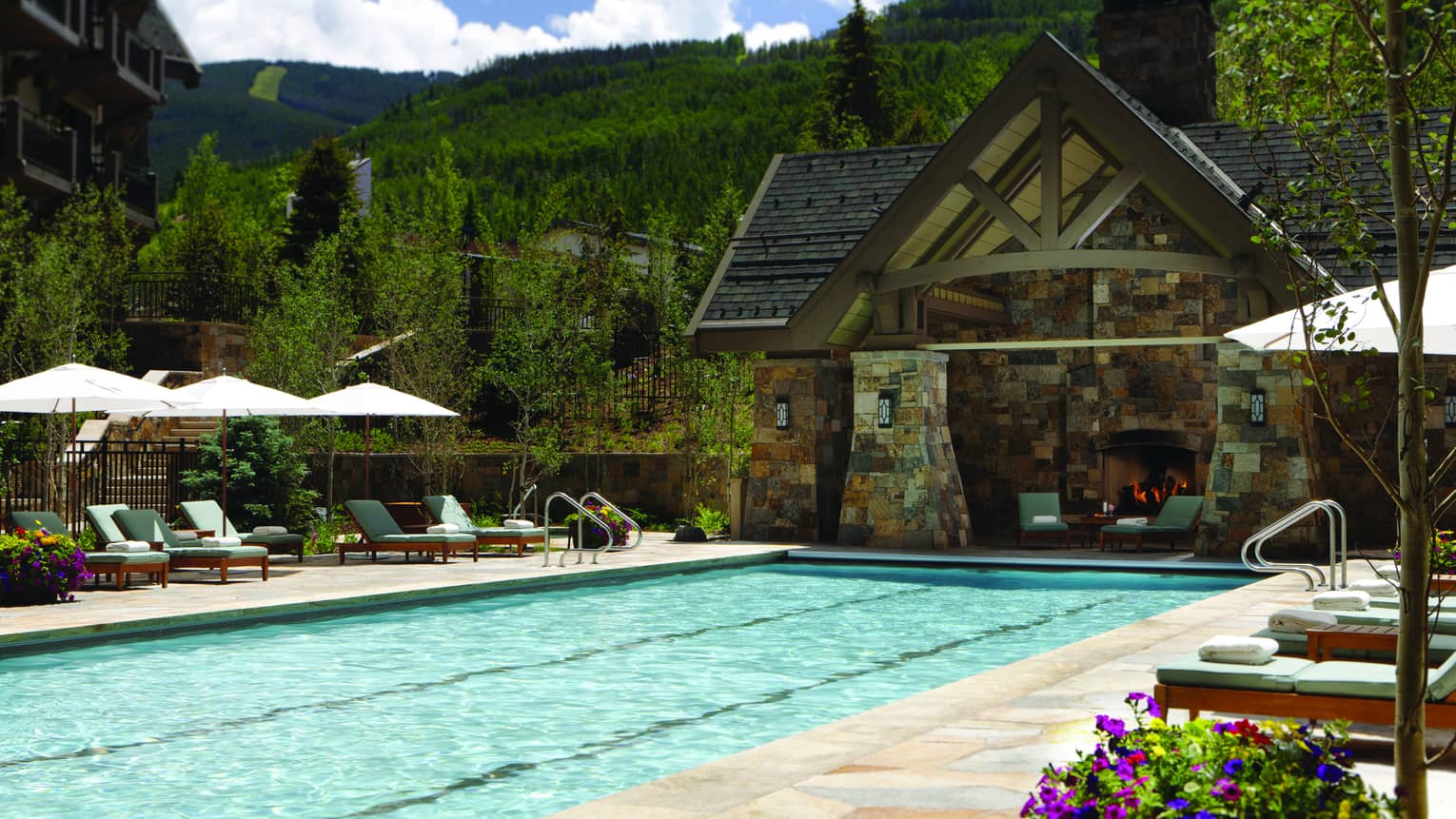 Outdoor lap pool at Four Seasons Resort Vail, lined with lounge chairs
