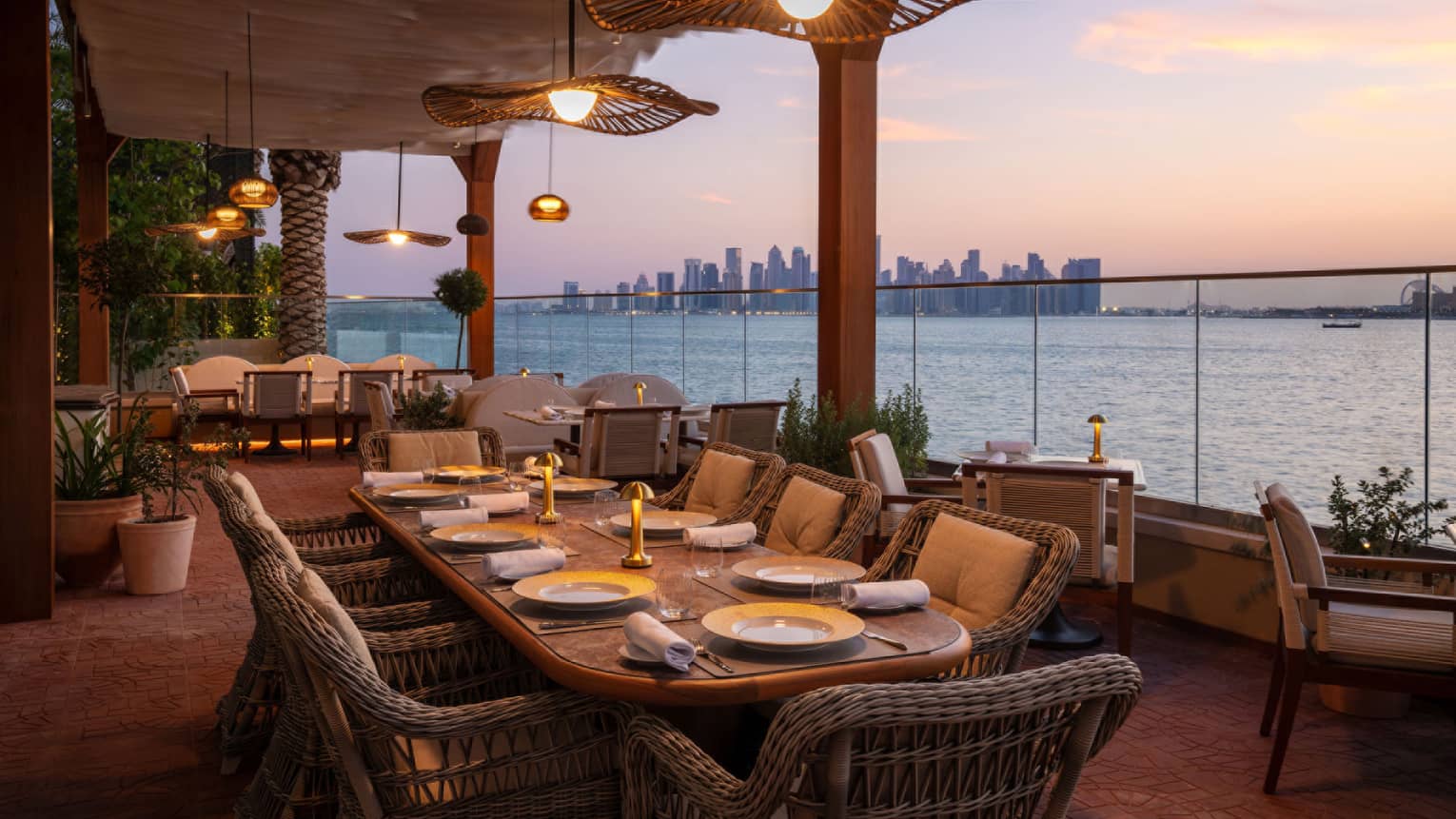 Outdoor restaurant terrace with sea view and Doha skyline in the distance