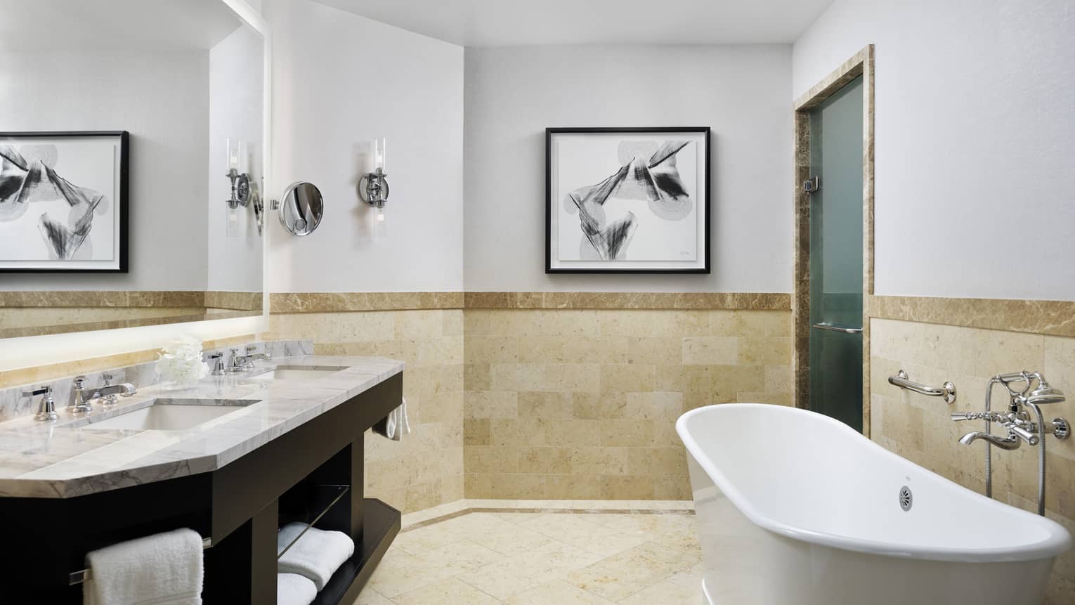 Double marbled vanity with two sinks, full-width mirror, large soaking tub, tiled wall at chair rail