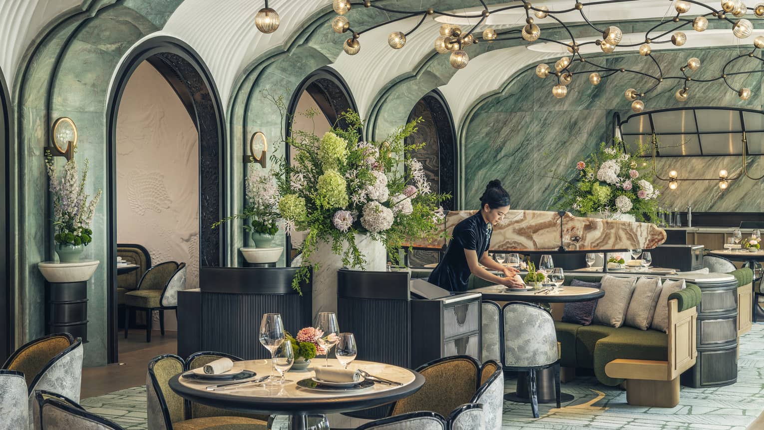 Woman sets table at contemporary Chinese restaurant Song at Four Seasons Hotel Hangzhou at Hangzhou Centre