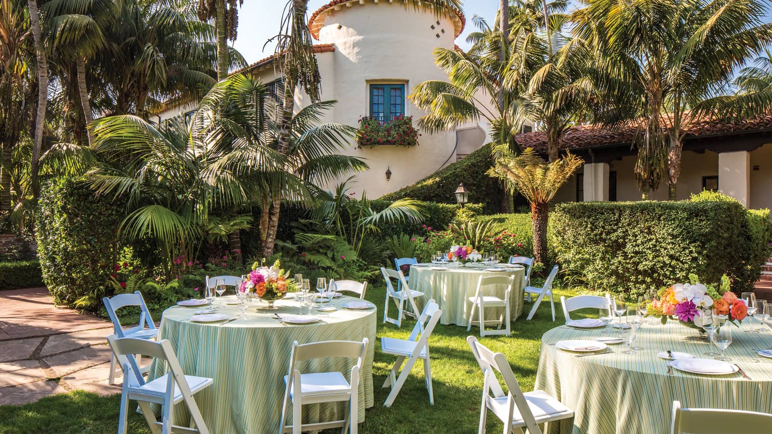 Escala Garden banquet tables on lawn under palm trees 