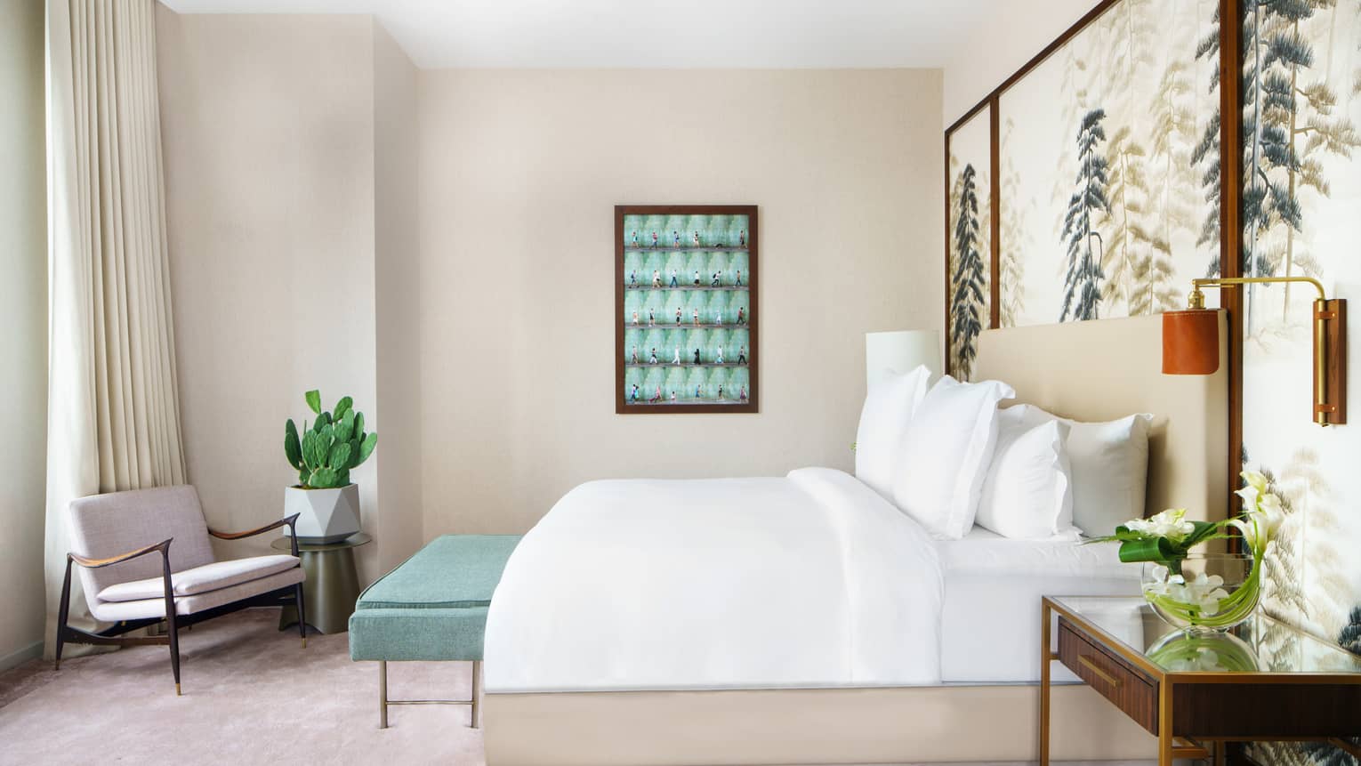 Bedroom with king bed, white linens, beige walls, light pink carpet, turquoise bench and wall art