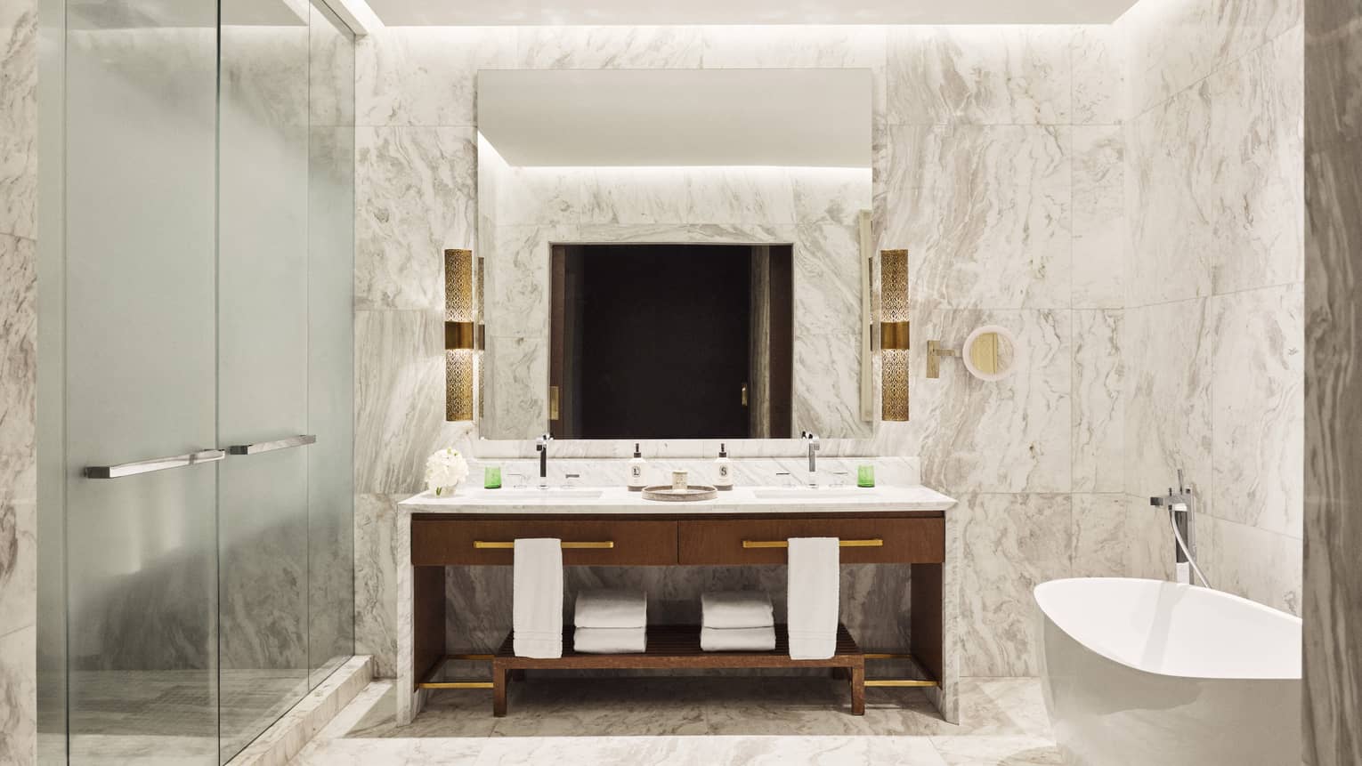 Marble bathroom with glass-enclosed shower, double vanity and standalone tub