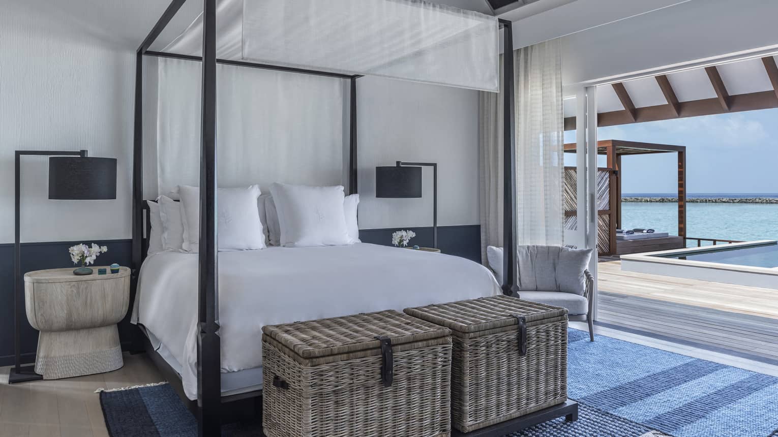 Sunrise Water Villa with Pool bedroom with four-poster bed, doorway opening onto deck with pool