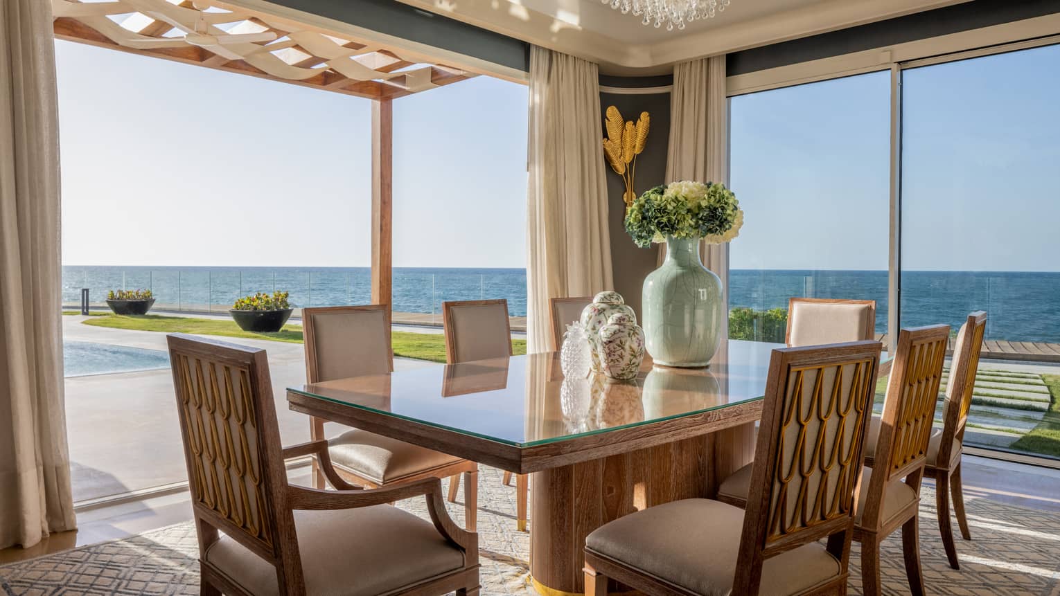 Open air dining area with sliding glass door to partially covered portico, ocean views