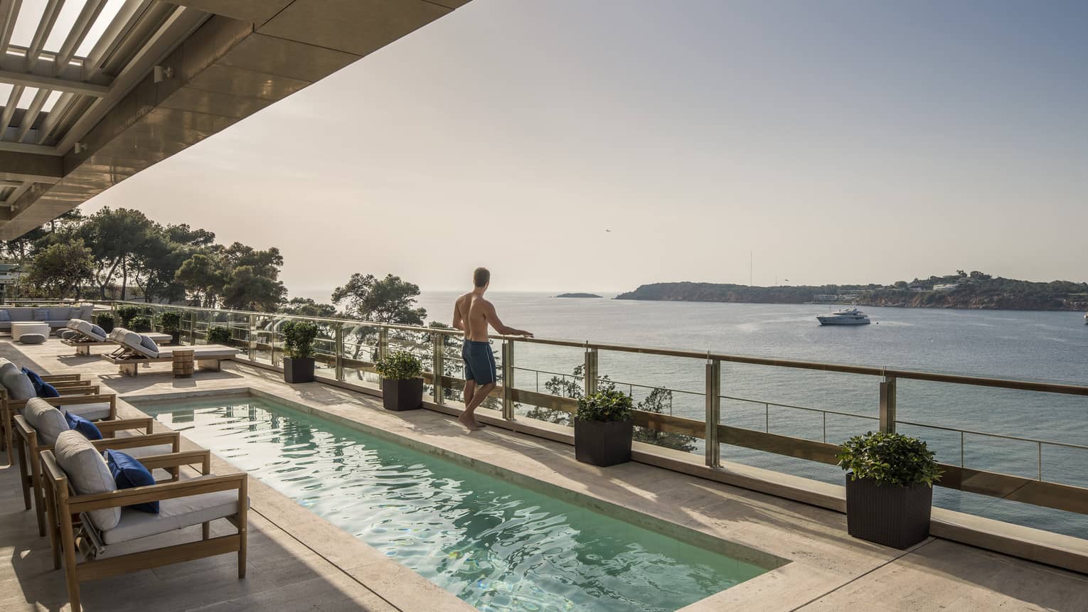 Arion Royal Suite Deck with lap pool and row of lounge chairs, boat on the Mediterranean Sea