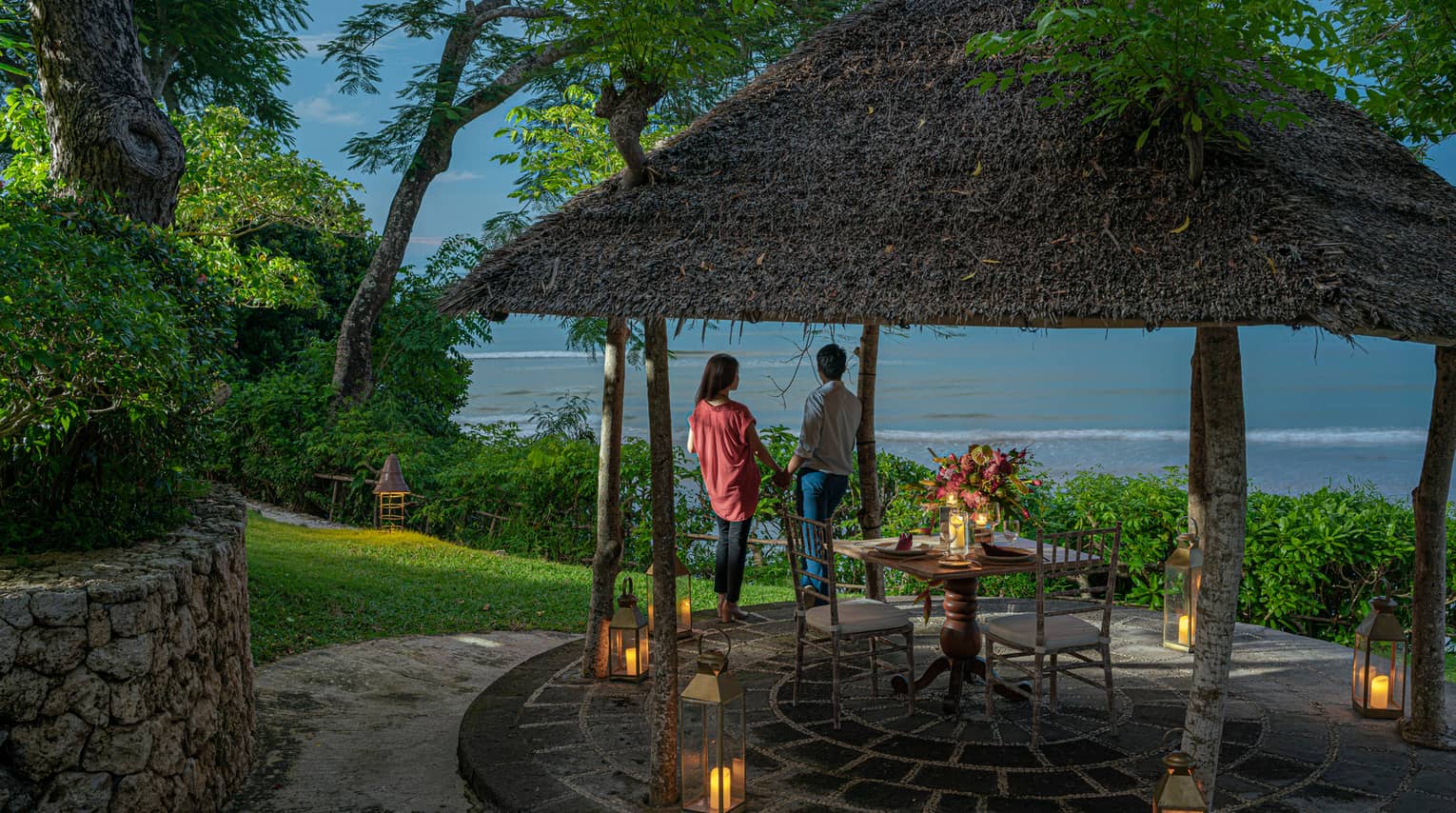 A couple enjoys a private outdoor dinner at dusk