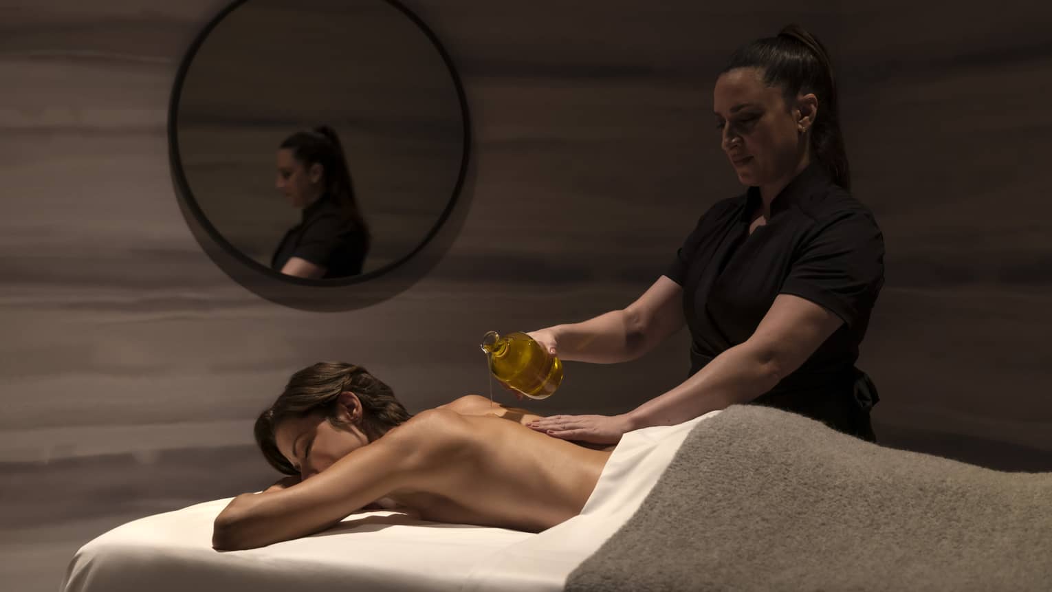 A woman getting a massage in a dimly lit room.