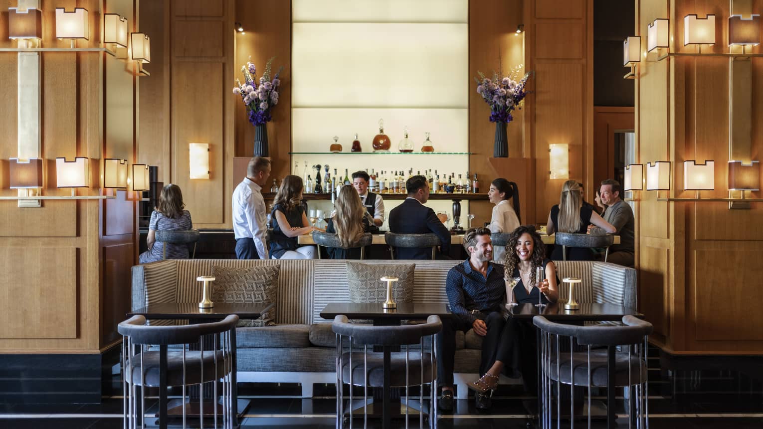 People sitting at a bar and booth in a dining outlet.