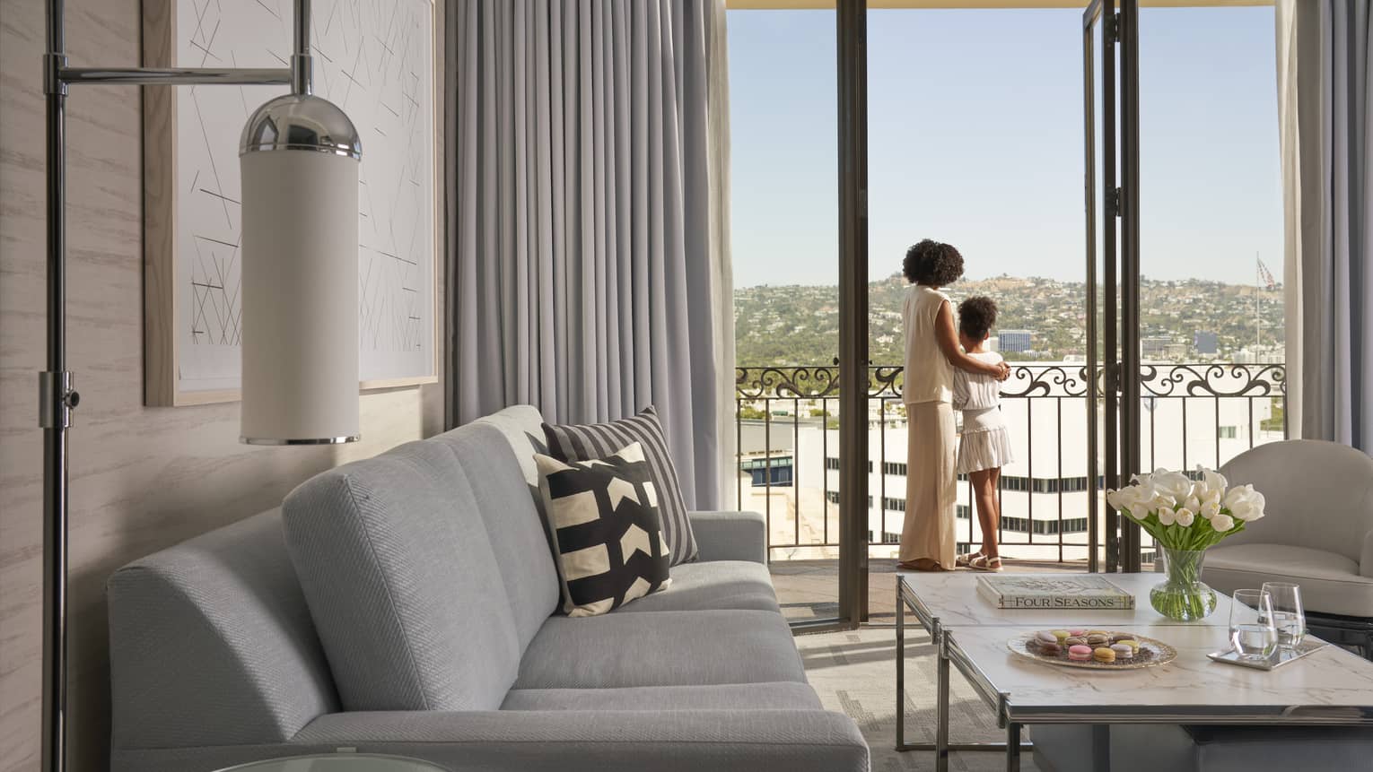 A mother and daughter looking out of a hotel window.