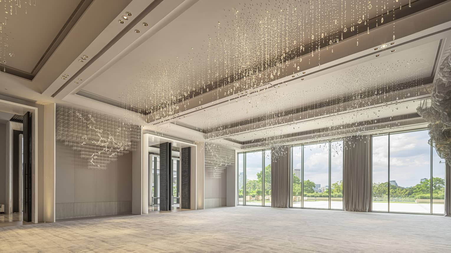 Grand Ballroom with cream-coloured carpeting and drapes, floor-to-ceiling windows and hanging crystal beads 