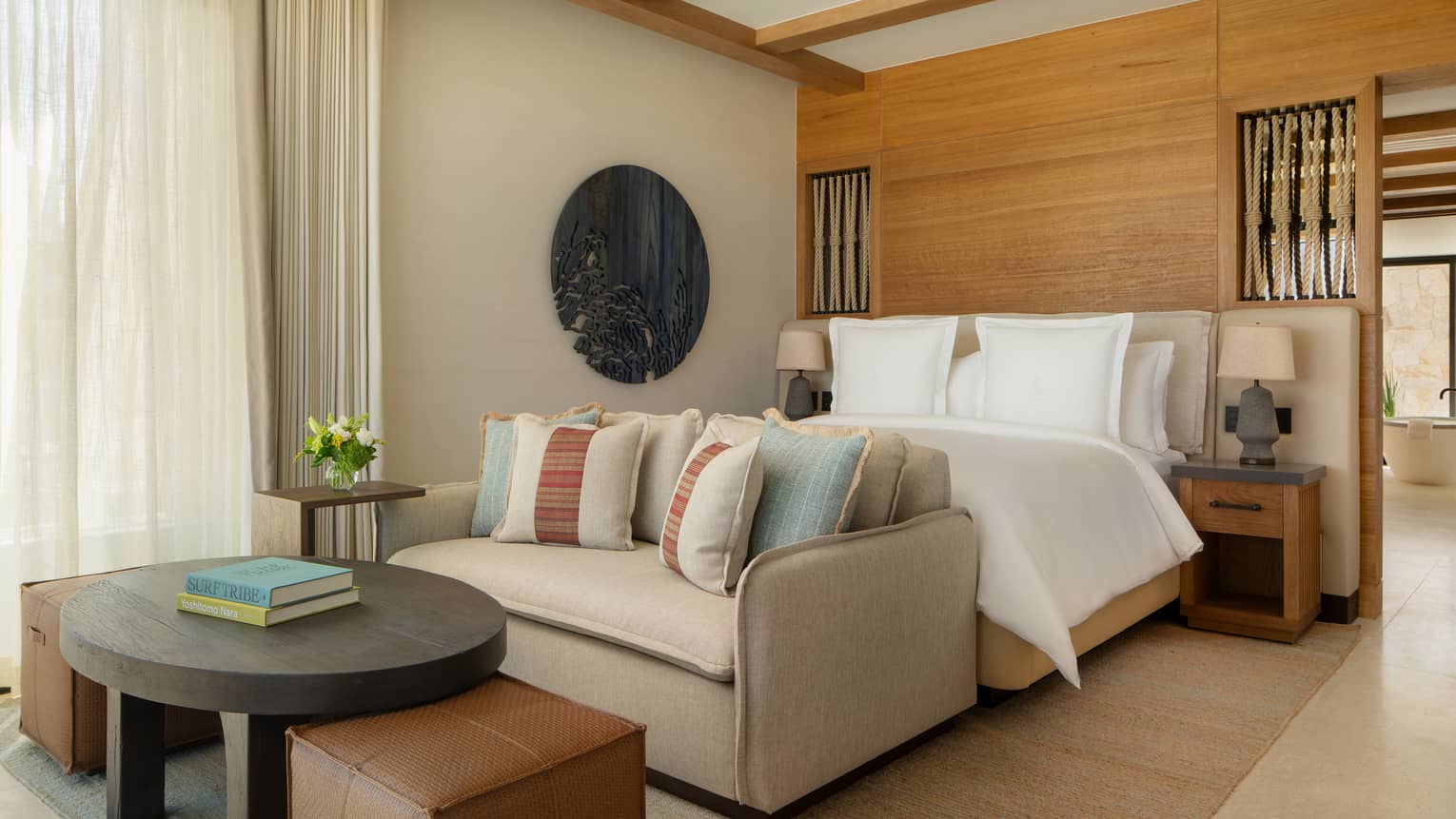 Luxury casita bedroom with king bed, sofa and two square leather ottomans at Four Seasons Resort Cabo San Lucas at Cabo Del Sol
