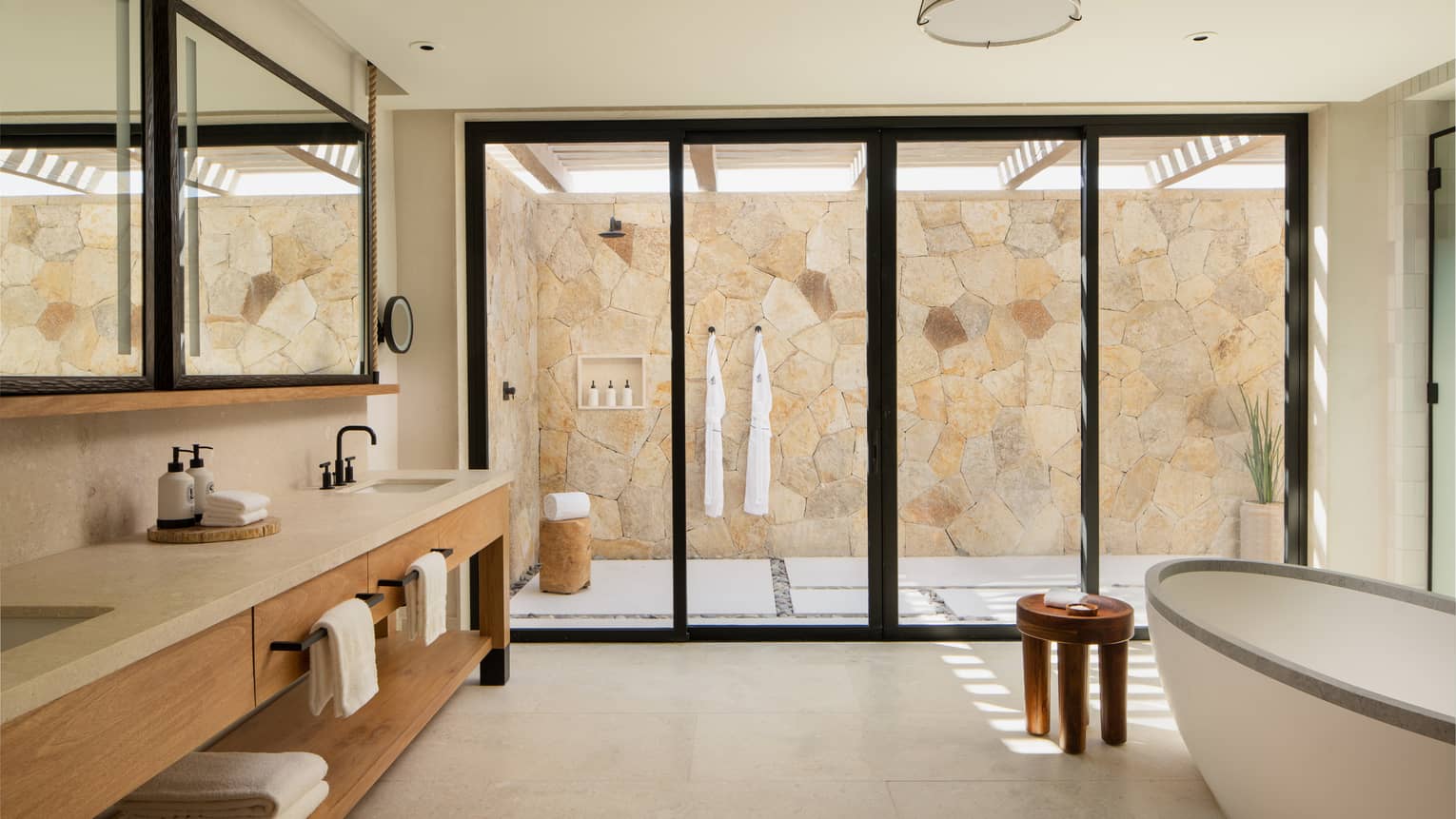 Large, chic bathroom with standalone tub, long double vanity and outdoor shower at Four Seasons Resort Cabo San Lucas at Cabo Del Sol