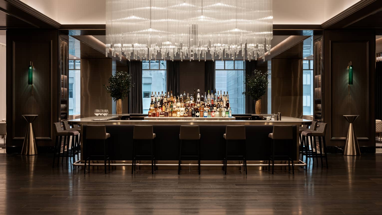 Bar area with dark wood floors and high chairs, modern rectangular lighting fixture hanging