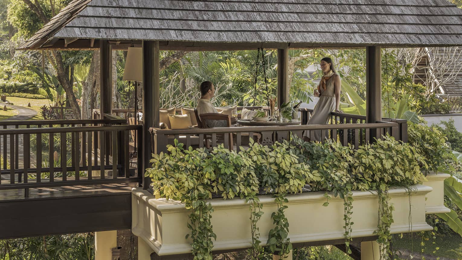 Couple enjoys a meal on the pavillion surrounded by greenery