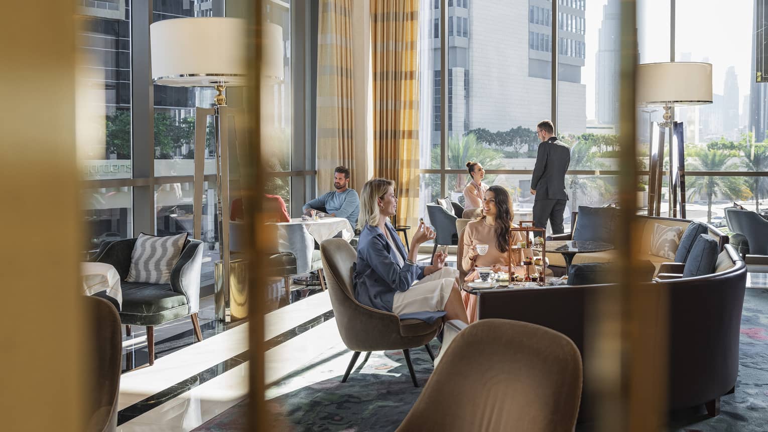 two ladies eating and drinking at city luxury hotel dining area