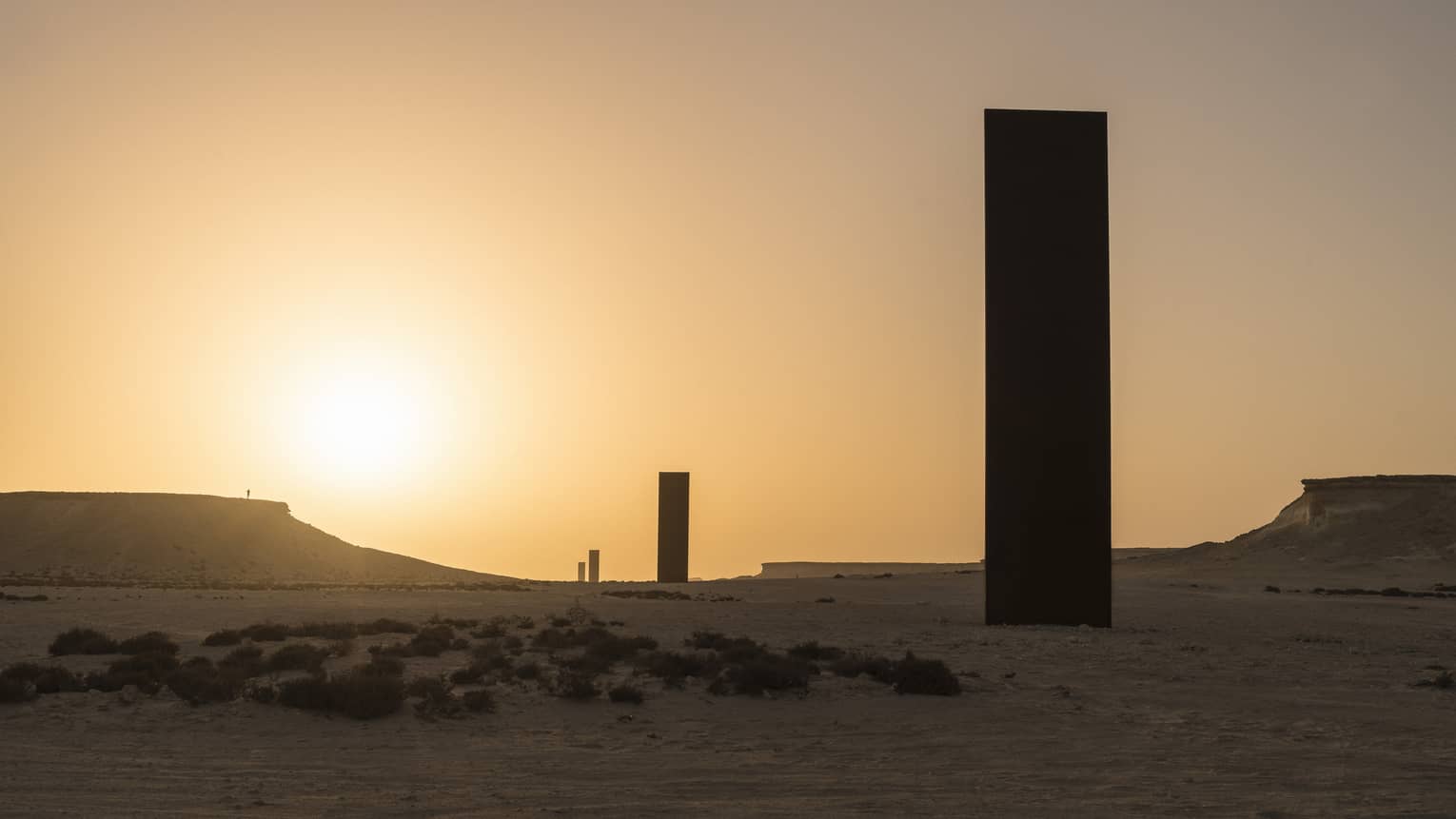 Silhouettes of Richard Serra Sculpture against sunset