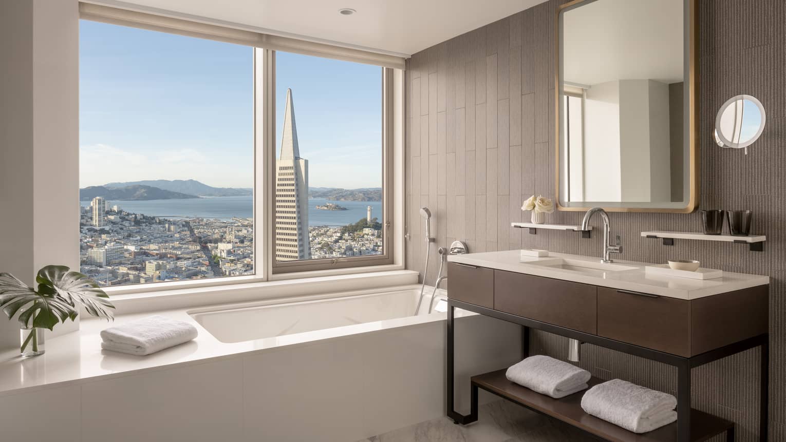 Hotel bathroom, featuring a window above the bathtub overlooking San Francisco
