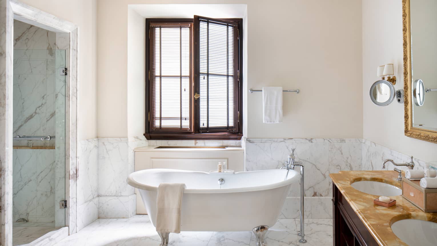 Bright Deluxe Room washroom with a shower, double sink and mirror and a clawfoot bathtub below an open window
