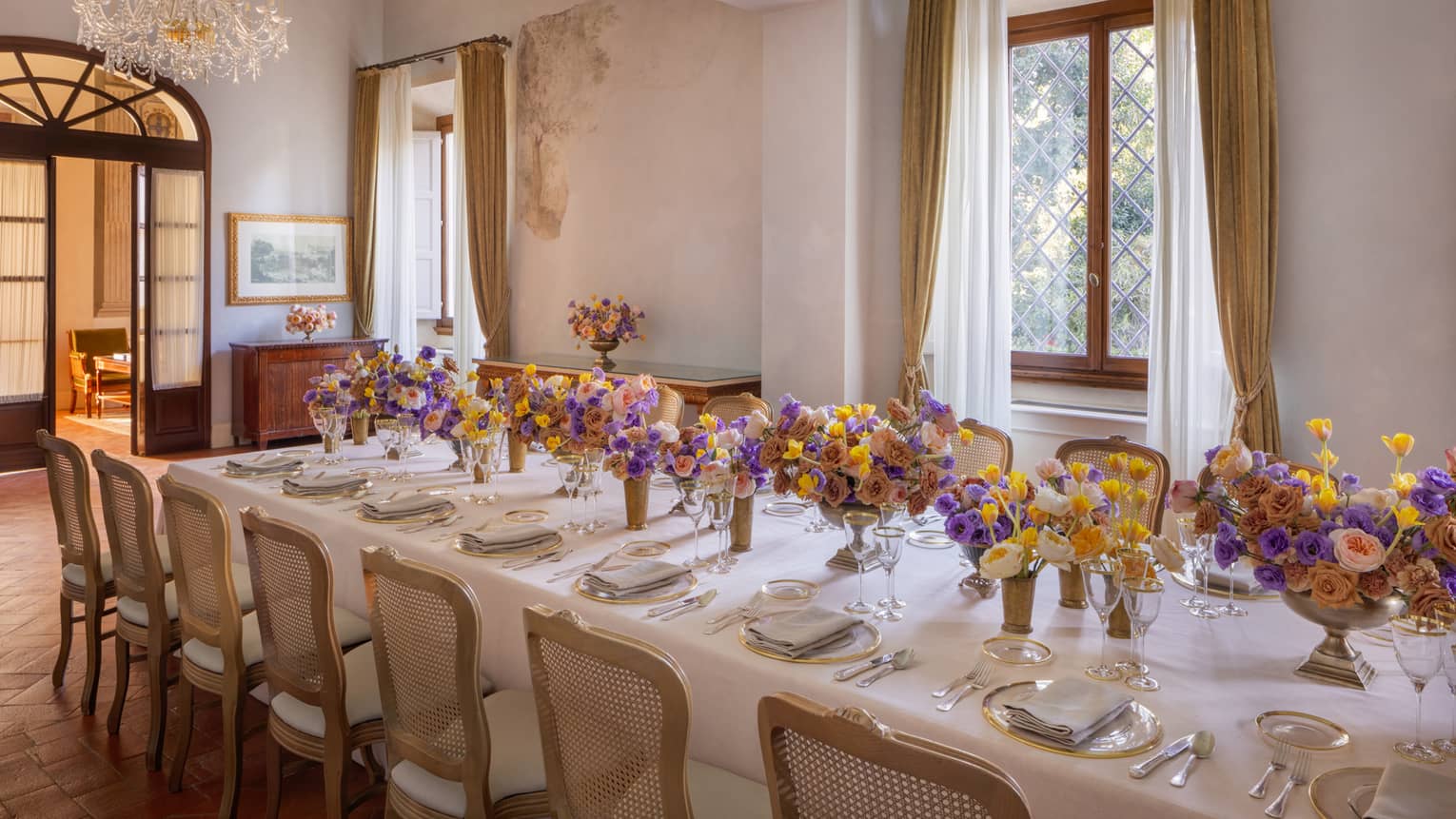 Meeting room with elegantly set long table with colourful flower centrepieces down the middle