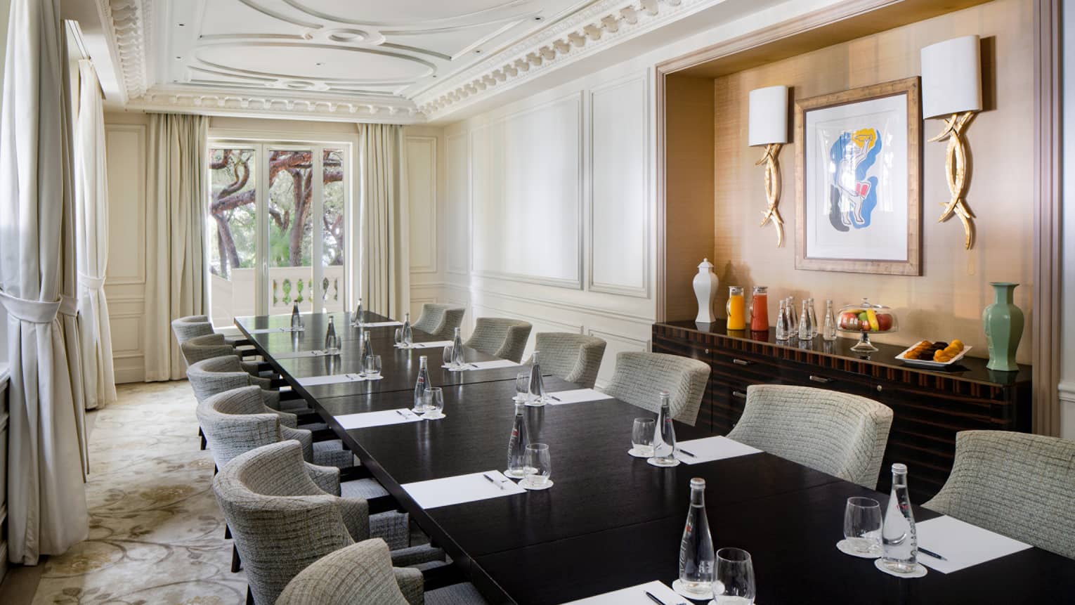 Salon Le Cap with conference table, gray rounded chairs, wood-panelled wall feature with art and sconces