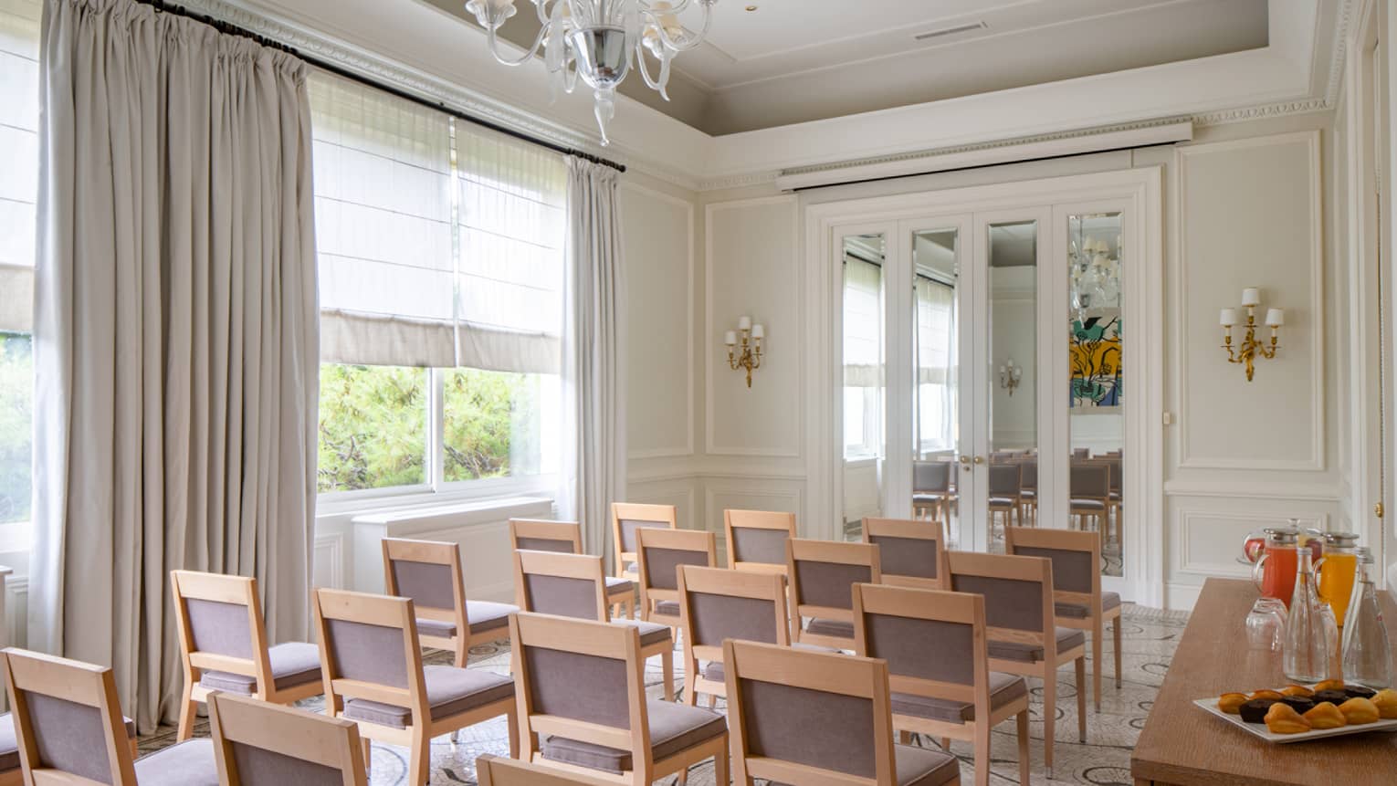 Salon Les Pins with classroom seating, curtained window, chandelier, French doors