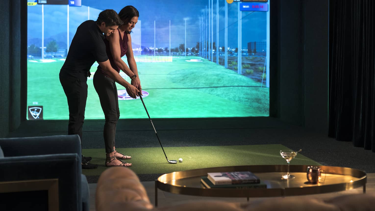 A man and woman golfing in a virtual golf room.