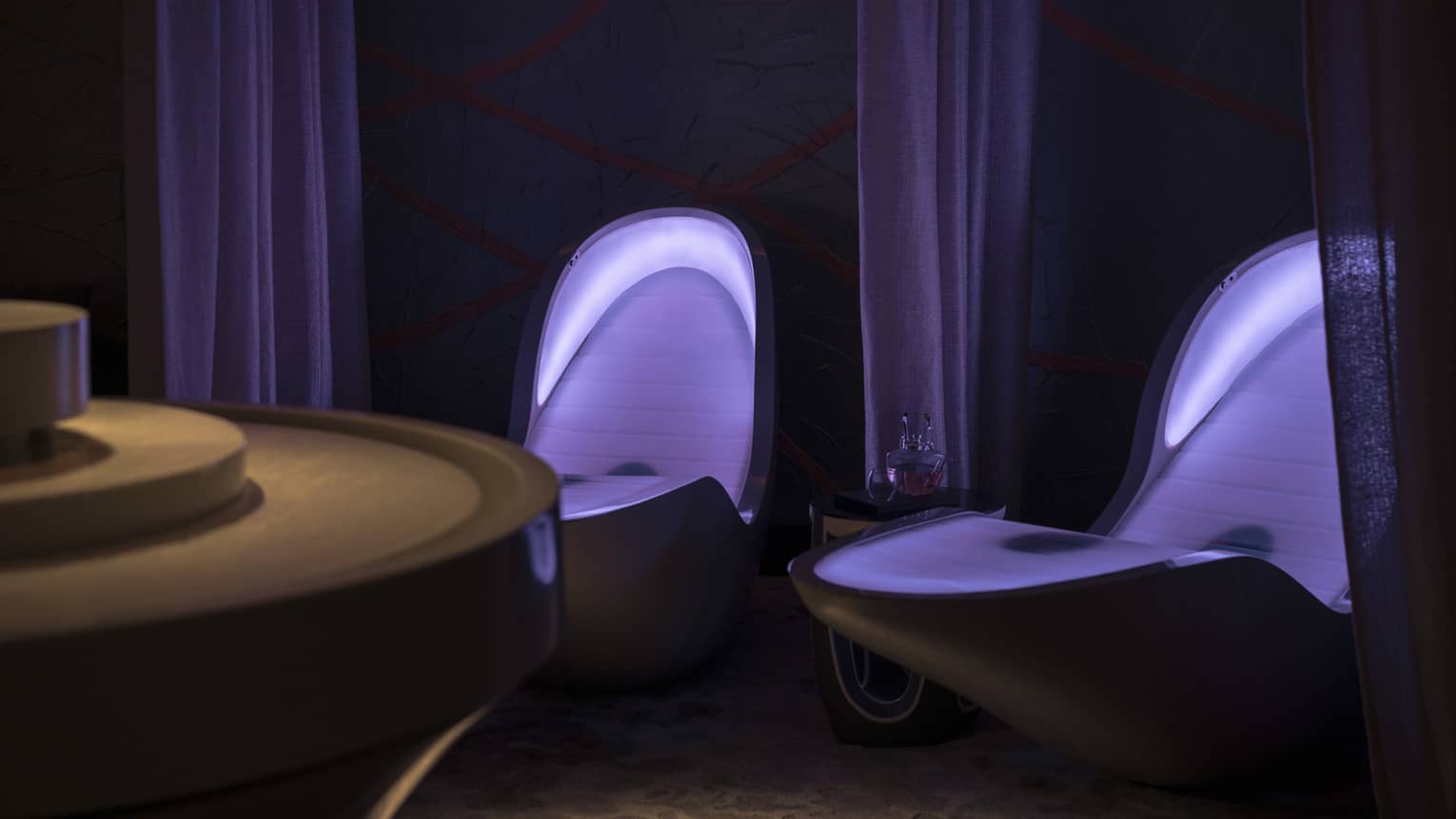 Illuminated four senses loungers in dark room