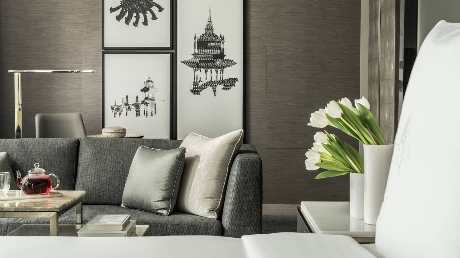 Corner Room seating area with art on the wall and some flowers arranged