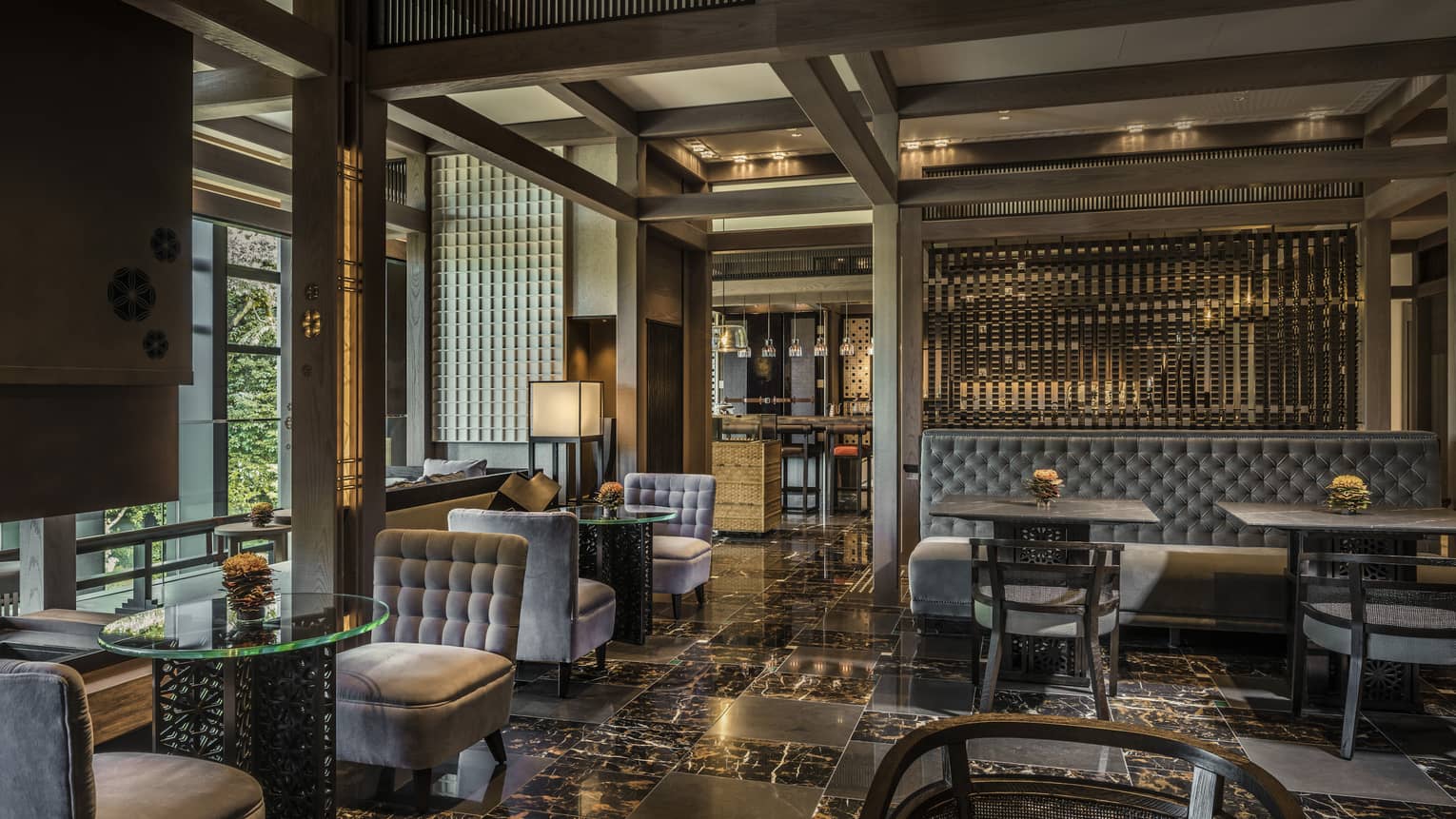Plush grey velvet sofas, chairs on black marble floors in The Lounge dining room