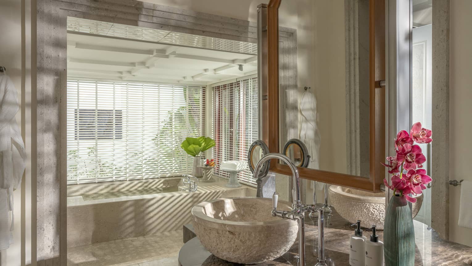 Luxury villa bathroom with two bowl sinks and a sunken tub next to window