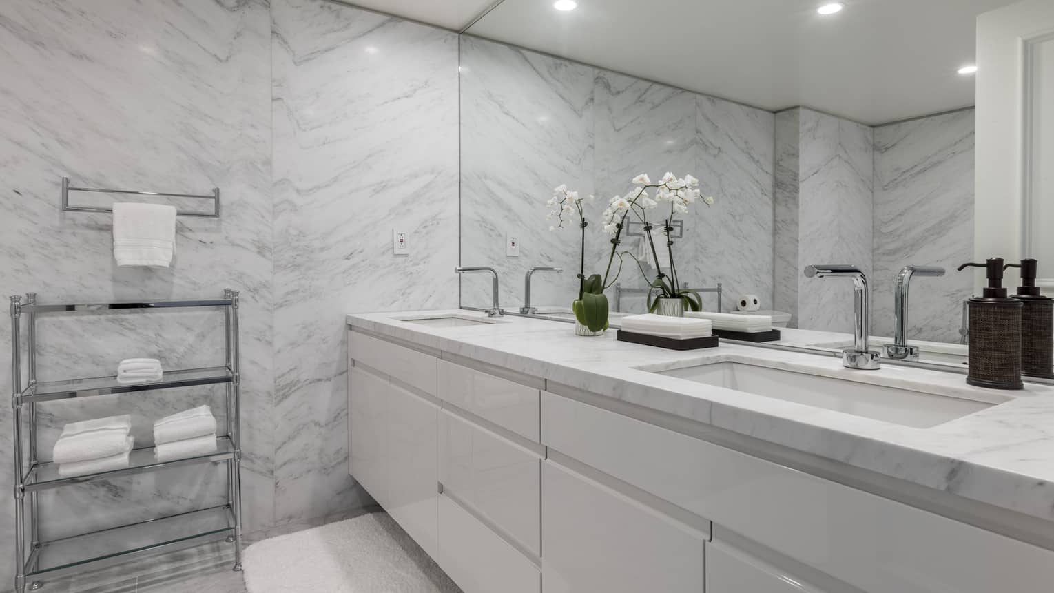 Bathroom with marble walls, white double vanity