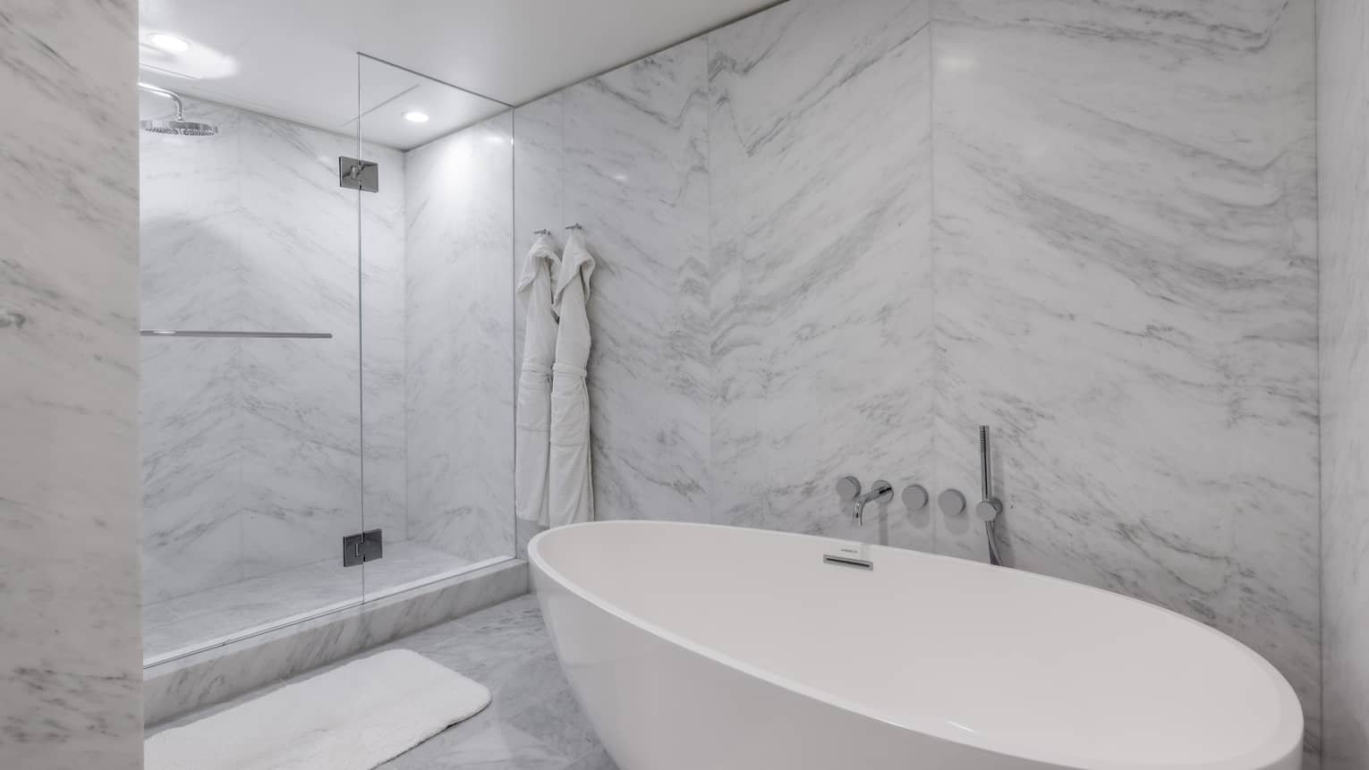Marble bathroom with freestanding oval tub, walk-in glass shower