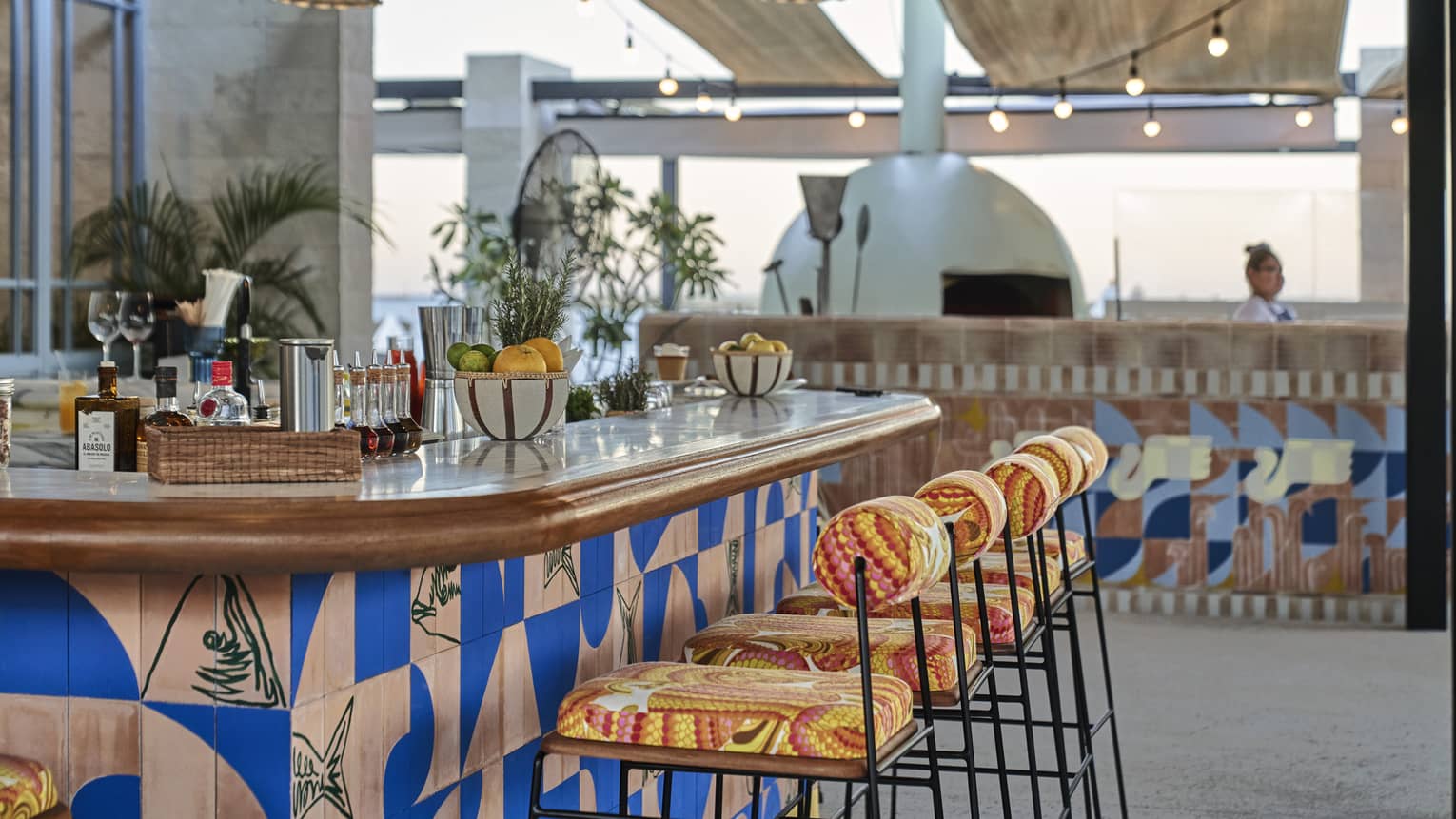 A bar with colourful stools and counter.