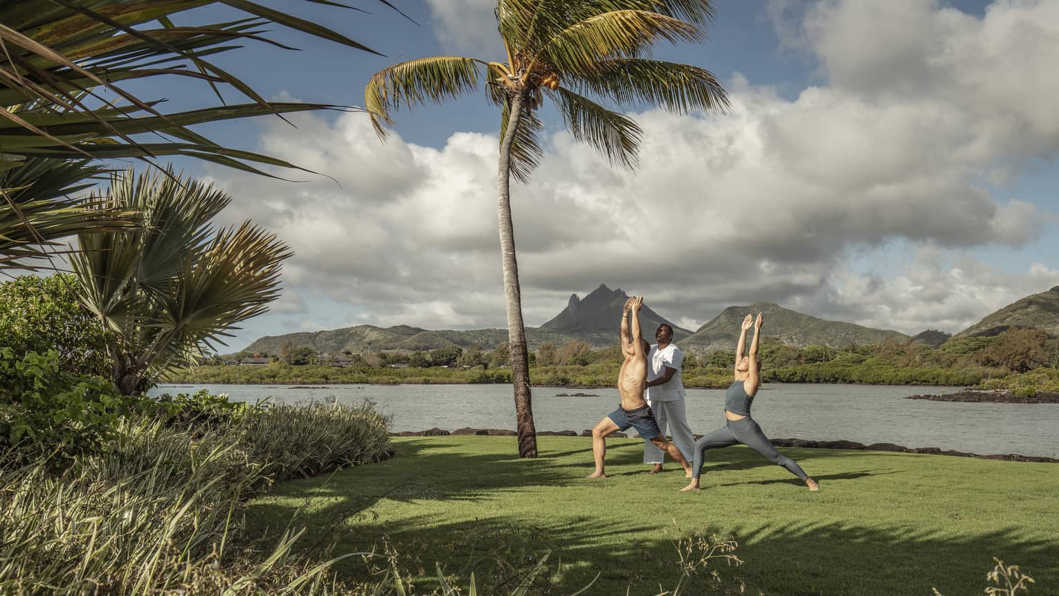 Yogi teaches a couple oceanfront yoga