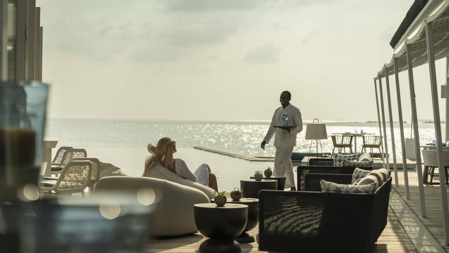 A guest receives a cocktail while relaxing outside at the Blu Beach Club