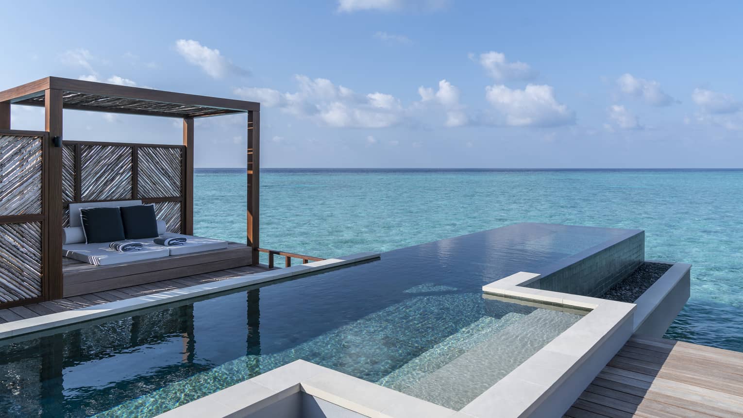 An oceanside infinity pool with a covered cabana 