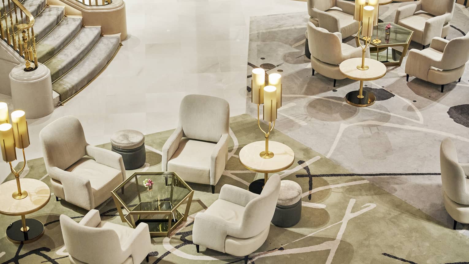 Aerial view of hotel lobby, four arm chairs around low coffee tables