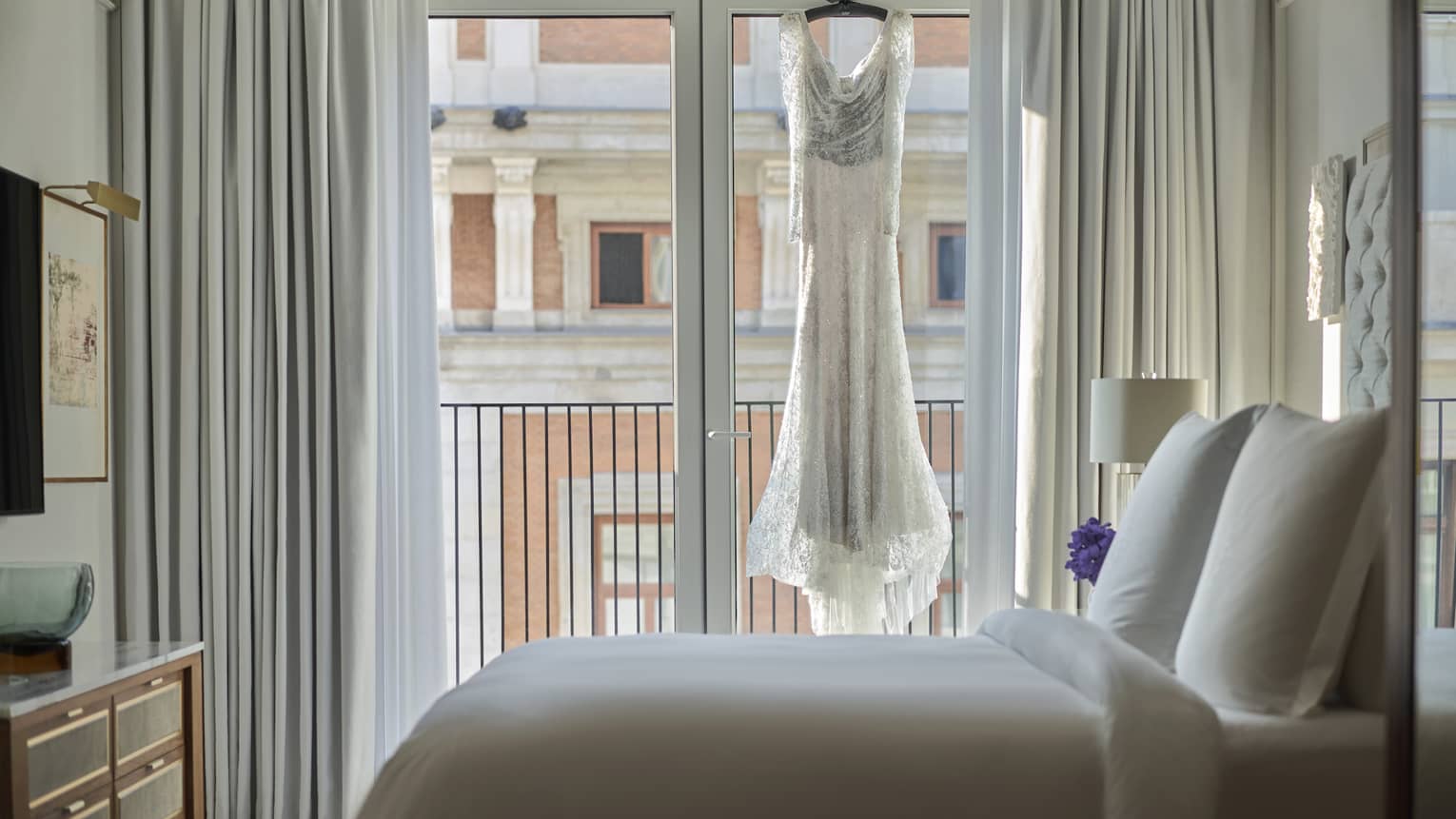 A wedding dress hangs in the window of a deluxe suite.