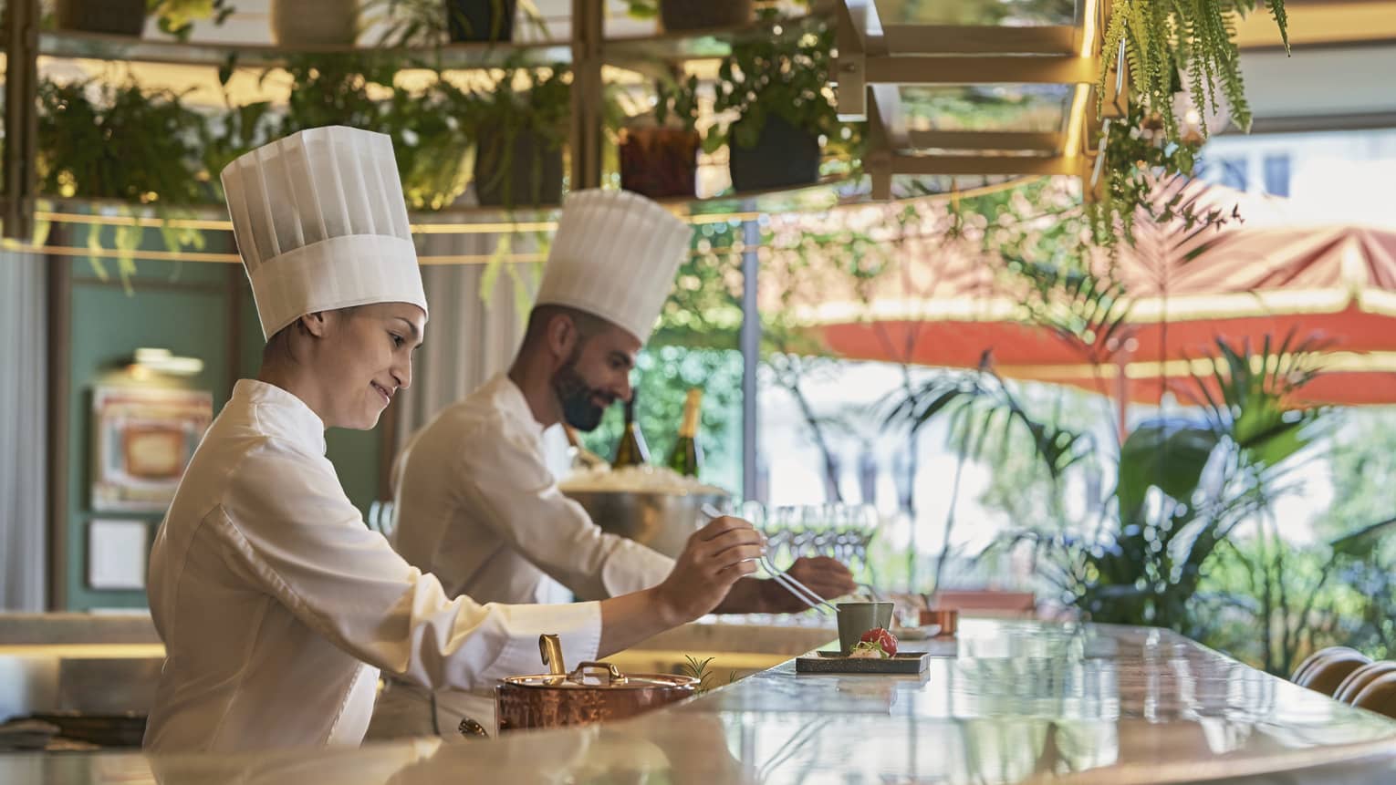 Male and female chef in action at bar counter of restaruant